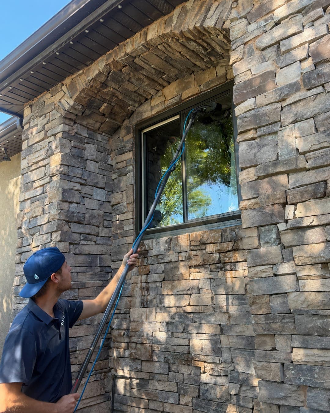 Glide technician cleaning an exterior window on a house