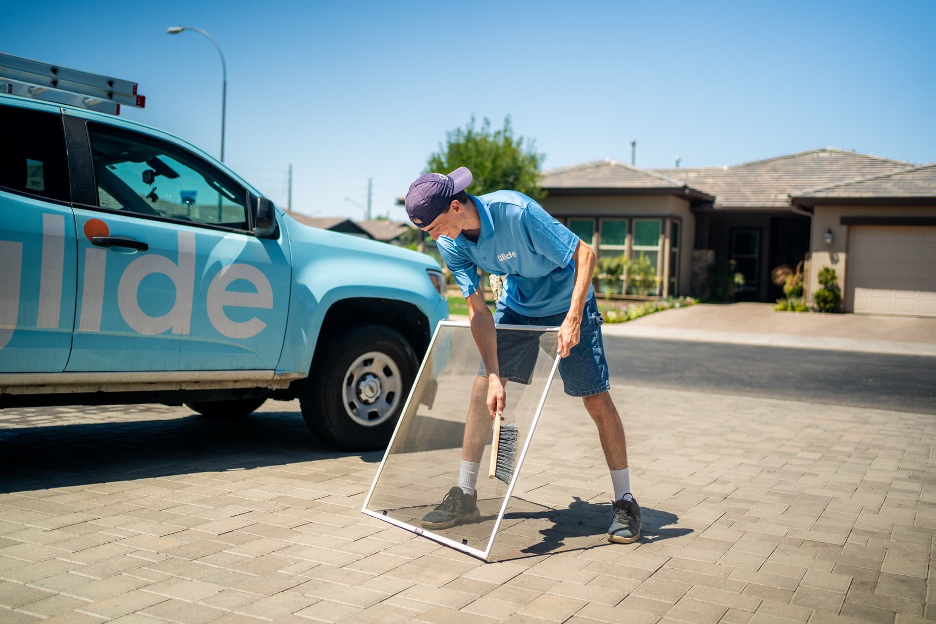 Technician carefully cleaning a window screen